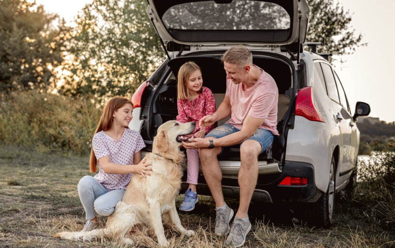 Family Sitting in Trunk of SUV with Dog