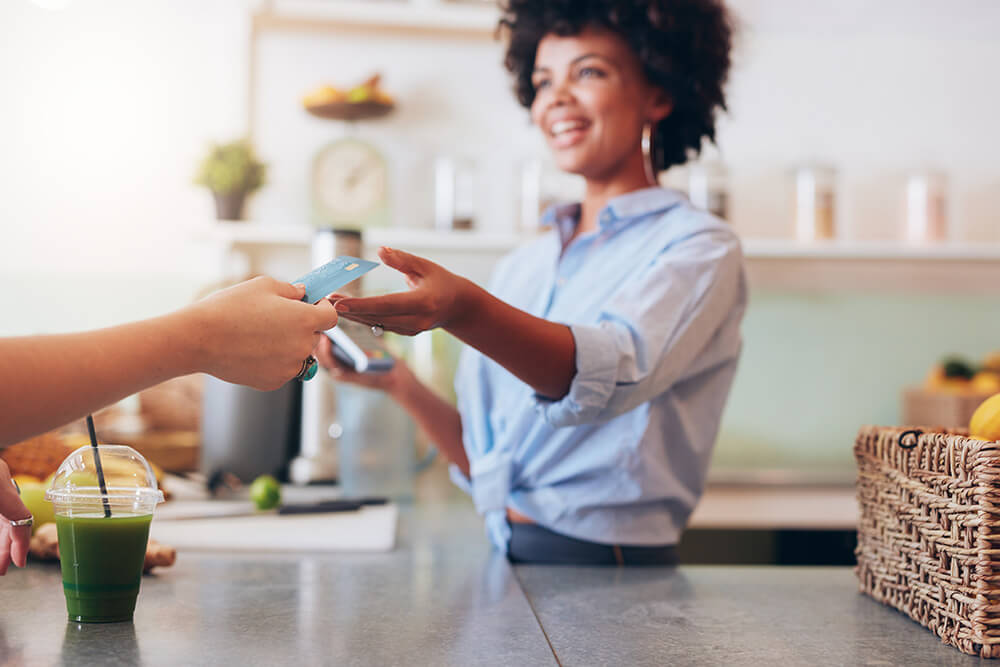 Woman business owner accepting credit card from customer