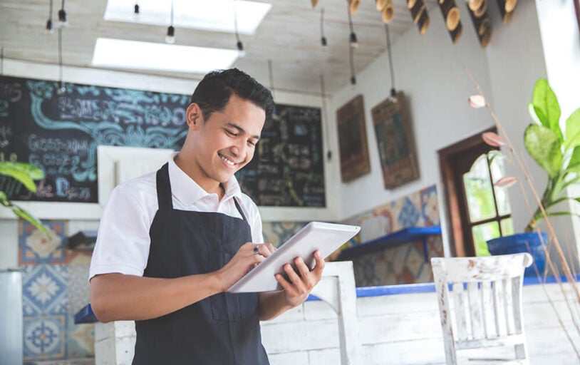 Man using iPad in his storefront