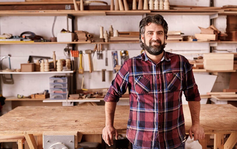 Man with a beard standing in wood working workshop