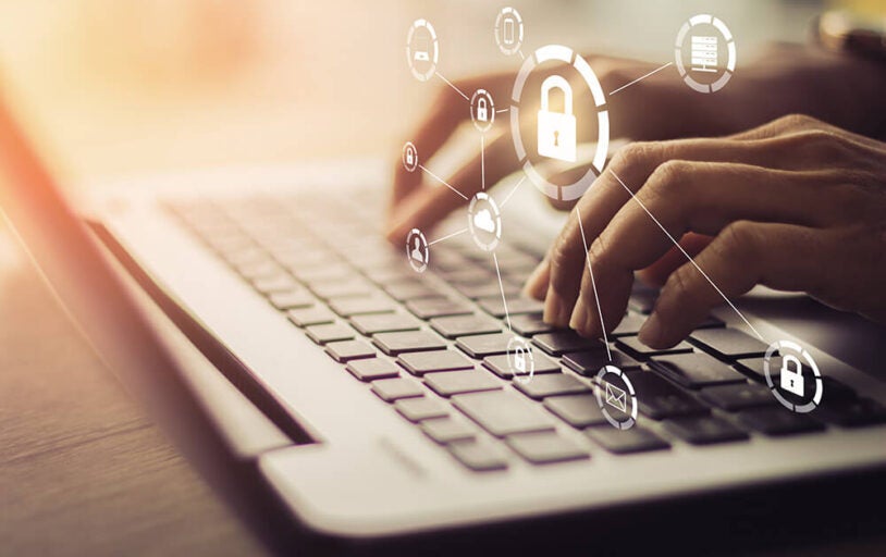 Hands on a laptop keyboard with a lock icon