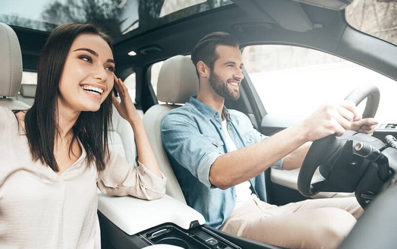 Man driving a car with a woman as a passenger