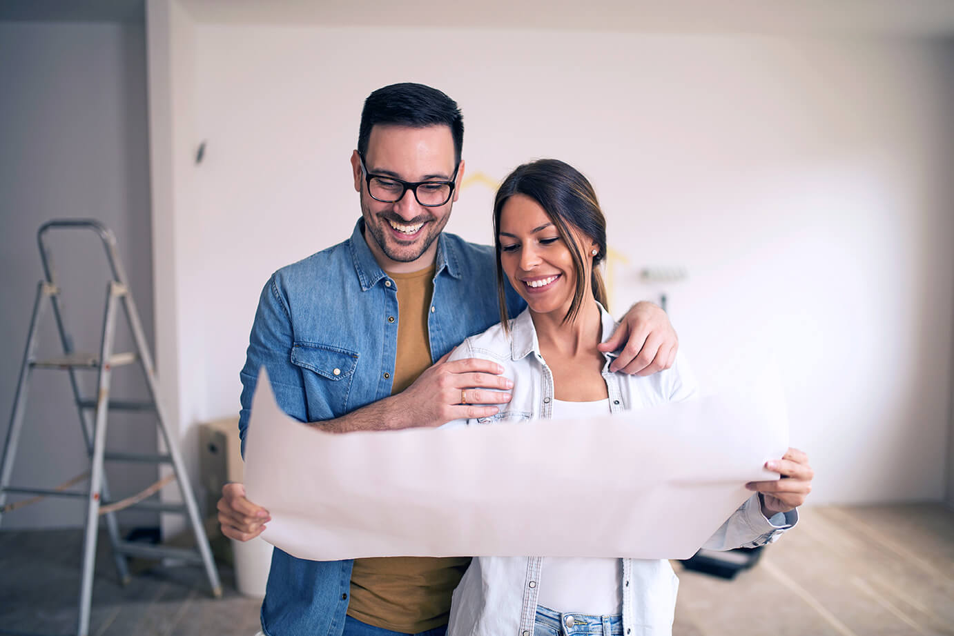 Couple holding blueprint of a home