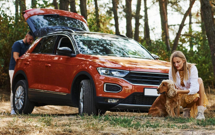 Couple and dog with car