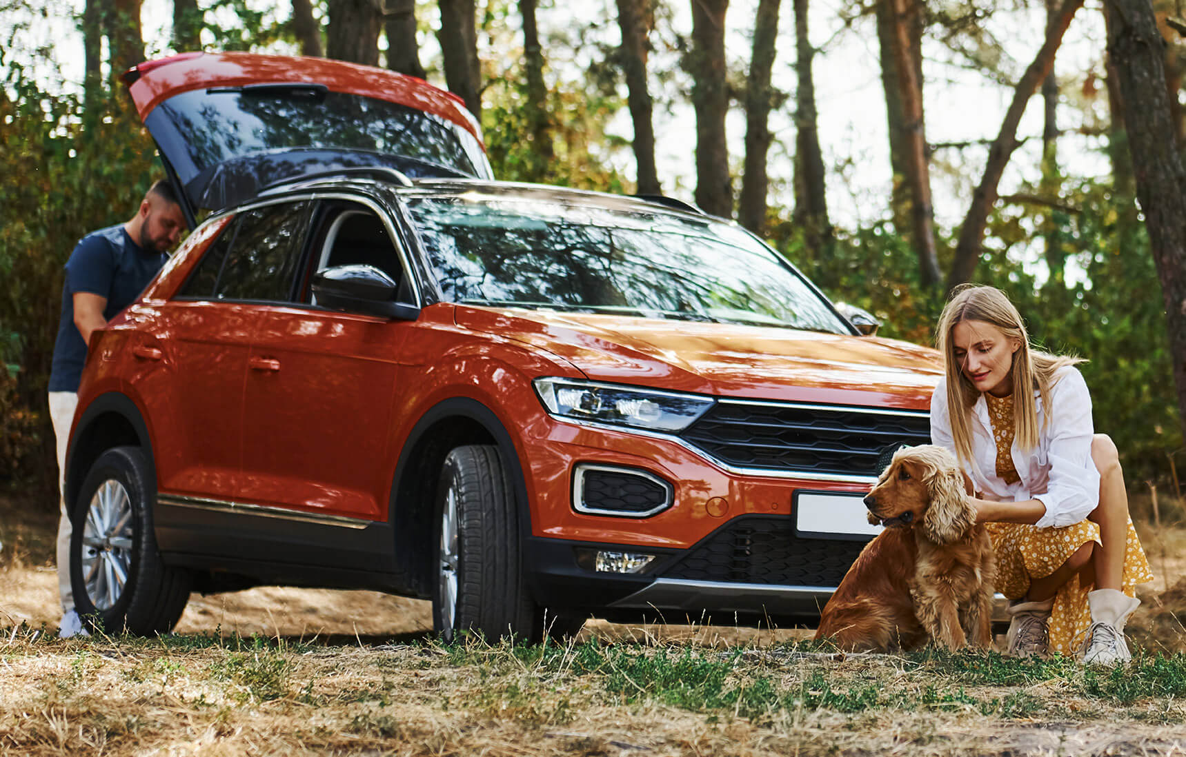 Couple and dog with car